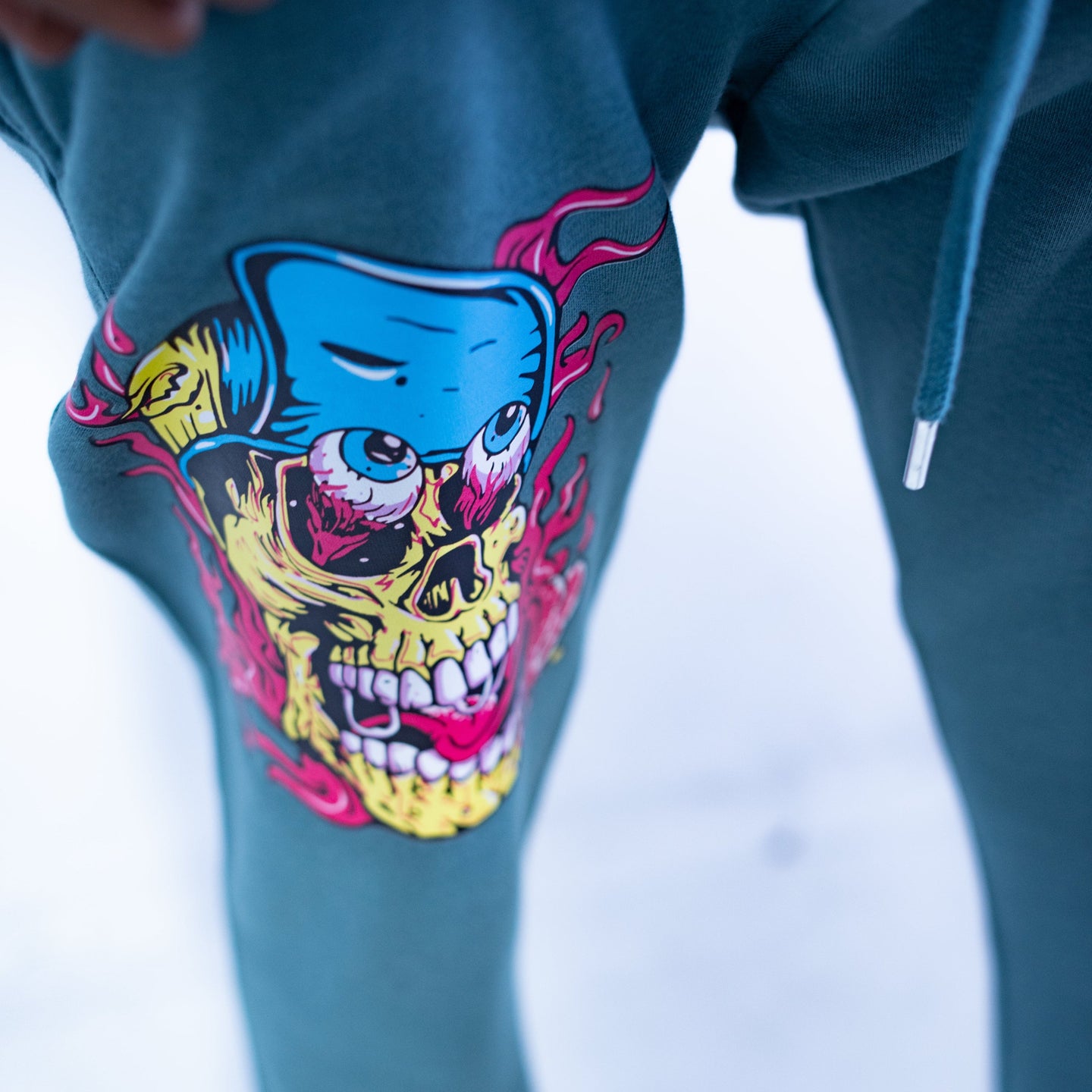 Blue sweatpants with a colorful skull design on a blurred background